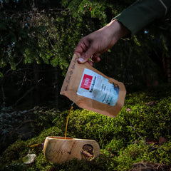 retkikahvi_tumma_paahto_kahwe_wolmark_taustalla_metsä